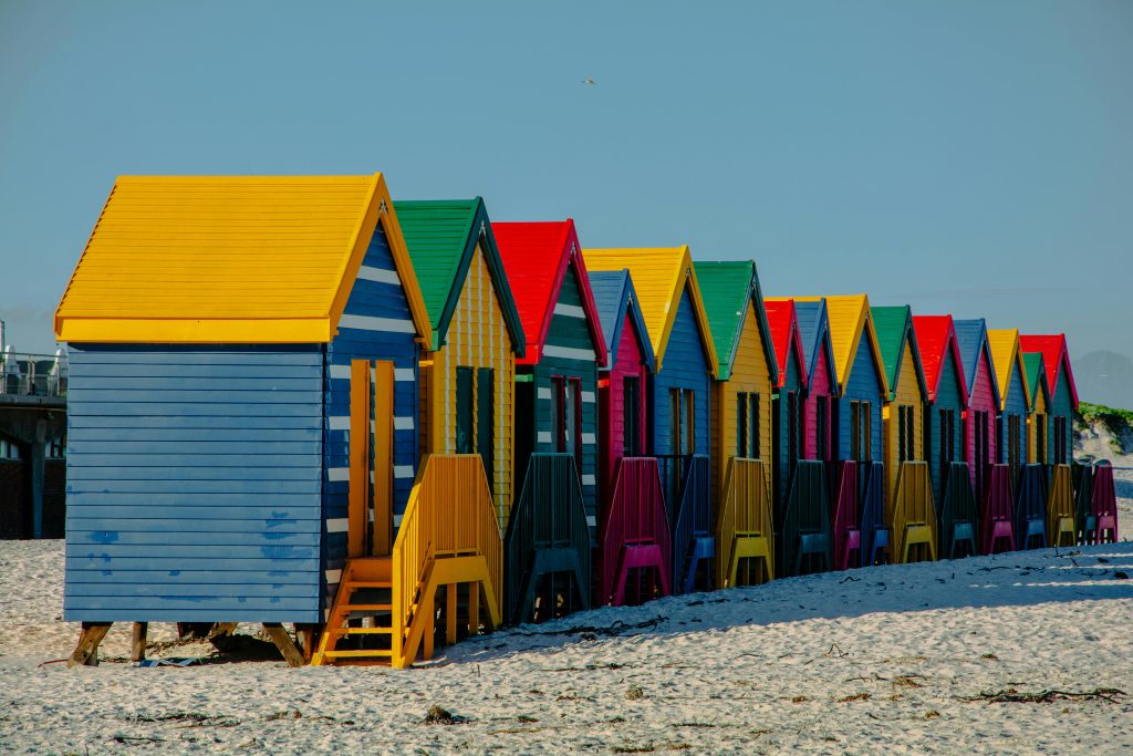 “Colourful Muizenberg beach huts on Muizenberg Beach in Cape Town, South Africa.”