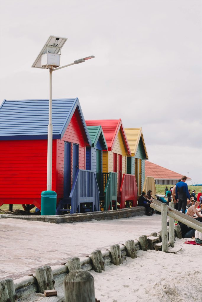 Colorful wooden Muizenberg Beach Huts at the edge of the beach, perfect for seaside photos